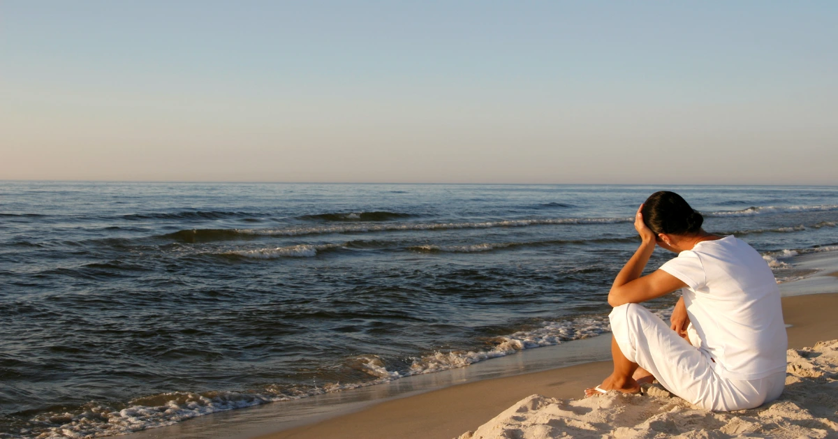 a girl sitting at the beach