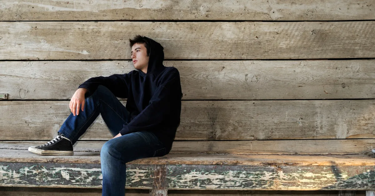 a guy sitting on a bench alone