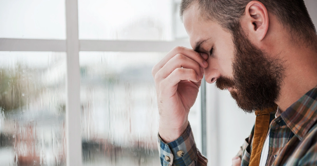 a guy pinching the top of his nose feeling hopeless