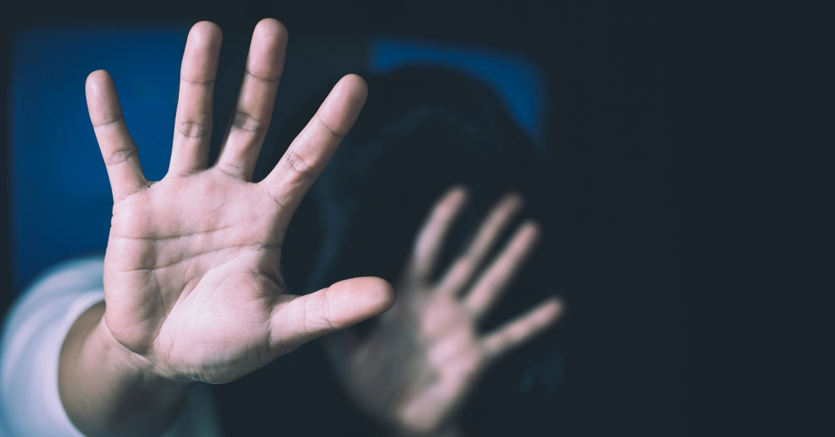a person placing their hands up in front of them to protect them from being physically abused