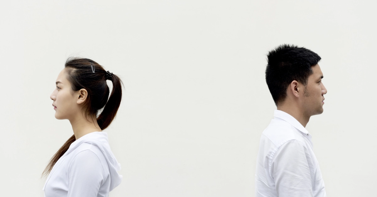 a couple standing back-to-back