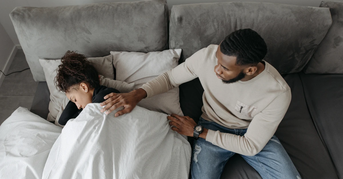 Guy comforting his friend who is sleeping.
