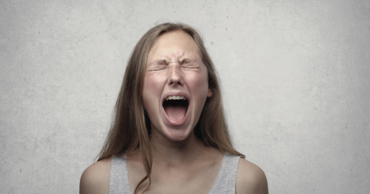 Girl closing her eyes and screaming.